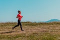 Young happy woman enjoying in a healthy lifestyle while jogging on a country road through the beautiful sunny forest Royalty Free Stock Photo