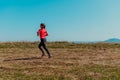 Young happy woman enjoying in a healthy lifestyle while jogging on a country road through the beautiful sunny forest Royalty Free Stock Photo