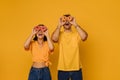 Young happy woman and enthusiastic man holding donuts on eyes Royalty Free Stock Photo