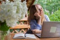 Young happy woman focuses on her laptop in wooden alcove. Relaxed outdoor setting emphasizes comfort and productivity Royalty Free Stock Photo