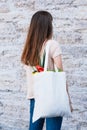 Young happy woman hold grocery tote shopping bag full of fresh vegetables. Royalty Free Stock Photo