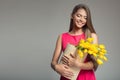 Young happy woman holding basket with yellow tulips. Royalty Free Stock Photo