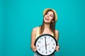 Young happy woman holding a clock with 12 clock on a green background. Portrait of positive pretty young woman with at wall clock Royalty Free Stock Photo