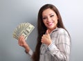 Young happy woman holding dollars and showing thumb up sign on b Royalty Free Stock Photo