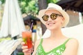 Young happy woman holding fresh cold strawberry mojito cocktail enjoying vacation at resort on hot sunny day. young caucasian bald Royalty Free Stock Photo