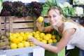 Happy woman holding lemons in hands in fruit store Royalty Free Stock Photo