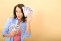 Young Happy Woman Holding Money Looking Pleased and Delighted