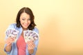 Young Happy Woman Holding Money Looking Pleased and Delighted