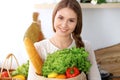 Young happy woman holding paper bag full of vegetables and fruits while smiling. Girl have made shopping and ready for Royalty Free Stock Photo