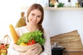 Young happy woman holding paper bag full of vegetables and fruits while smiling. Girl have made shopping and ready for Royalty Free Stock Photo