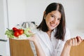 Happy woman holding plate with fresh lettuce, cherry tomatoes, arugula in kitchen. Healthy eating Royalty Free Stock Photo