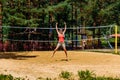 A young woman jumps on the volleyball field at the beach