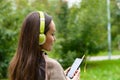 Young happy woman listening music from smartphone with headphones in a quiet Park Royalty Free Stock Photo