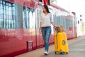 Young happy woman with luggage at a train station Royalty Free Stock Photo