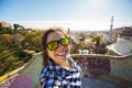 Young happy woman making selfie portrait with smartphone in Park Guell, Barcelona, Spain. Beautiful girl looking at Royalty Free Stock Photo