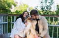 Young happy woman and man hug their cute aussie dog in a park. Royalty Free Stock Photo