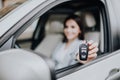 Young happy woman near the car with keys in hand. Concept of buying car. Focus on key. Royalty Free Stock Photo