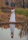 Young happy woman in a park near the river in autumn season Royalty Free Stock Photo