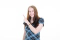 Young happy woman points finger to the side of white empty space mockup