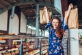 Young happy woman raising hands with shopping paper bags in shopping center