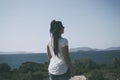 Young happy woman with rasta stands on to the rock. Traveler enj