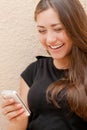 Young happy woman reading message on mobile phone Royalty Free Stock Photo