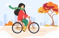 Young happy woman rides a bicycle in the autumn city park