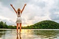 Young happy woman rising hands up enjoying beautiful sunset Royalty Free Stock Photo