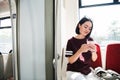 Young happy woman sitting in city bus and using her mobile phone. Royalty Free Stock Photo