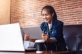 Young happy woman sitting on sofa and using a tablet, laptop on the table in front of her. relaxing concept Royalty Free Stock Photo