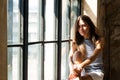 Young happy woman sitting on a window-sill and looking outside Royalty Free Stock Photo