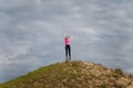 Young happy woman in sportswear jumping on hill with arms up to sky. Fitness, healthy way of life, wellbeing, freedom mental healh Royalty Free Stock Photo