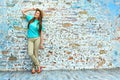 Young happy woman standing against brick wall. Royalty Free Stock Photo