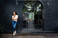 Young happy woman standing outside a coffee shop using her phone Royalty Free Stock Photo