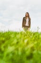 Young happy woman standing outside in green field Royalty Free Stock Photo