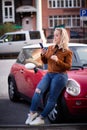 Young happy woman taking new photos on smartphone on the street. Girl doing selfies for social nets on the road with Royalty Free Stock Photo