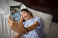 Young happy woman taking selfie with mobile phone in bedroom mo Royalty Free Stock Photo