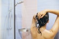 Young happy woman taking shower at home or hotel bathroom. Beautiful  brunette girl washing her hair and enjoying relax time. Body Royalty Free Stock Photo