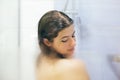 Young happy woman taking shower at home or hotel bathroom. Beautiful  brunette girl washing her hair and enjoying relax time. Body Royalty Free Stock Photo