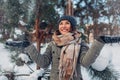 Young happy woman throwing snow in winter forest. Girl having fun outdoors. Snowy activities Royalty Free Stock Photo