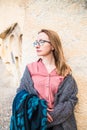 Young happy woman traveler enjoying a vacation in desert Cappadocia Turkey. Tourist blonde girl in glasses and pink shirt outdoor