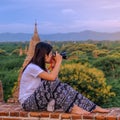 Young happy woman traveling, Asian traveler take a photo on Pagoda and looking Beautiful ancient temples, landmark and popular for Royalty Free Stock Photo