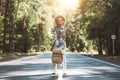 Young happy woman with traveling backpack wearing hat stand alone on countryroad Royalty Free Stock Photo