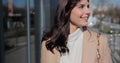 Young happy woman using smartphone and drinking coffee to go outdoors, walking down the city street. Royalty Free Stock Photo