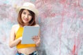 Young happy woman using tablet computer over wall background looking at camera with copy space..Portrait pretty charming confident Royalty Free Stock Photo