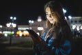 Young happy woman using tablet outdoors over blurry night city lights Royalty Free Stock Photo