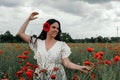 Young happy woman walking in a blooming poppy field Royalty Free Stock Photo