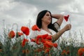 Young happy woman walking in a blooming poppy field Royalty Free Stock Photo