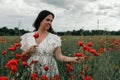 Young happy woman walking in a blooming poppy field Royalty Free Stock Photo