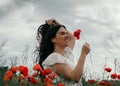Young happy woman walking in a blooming poppy field Royalty Free Stock Photo